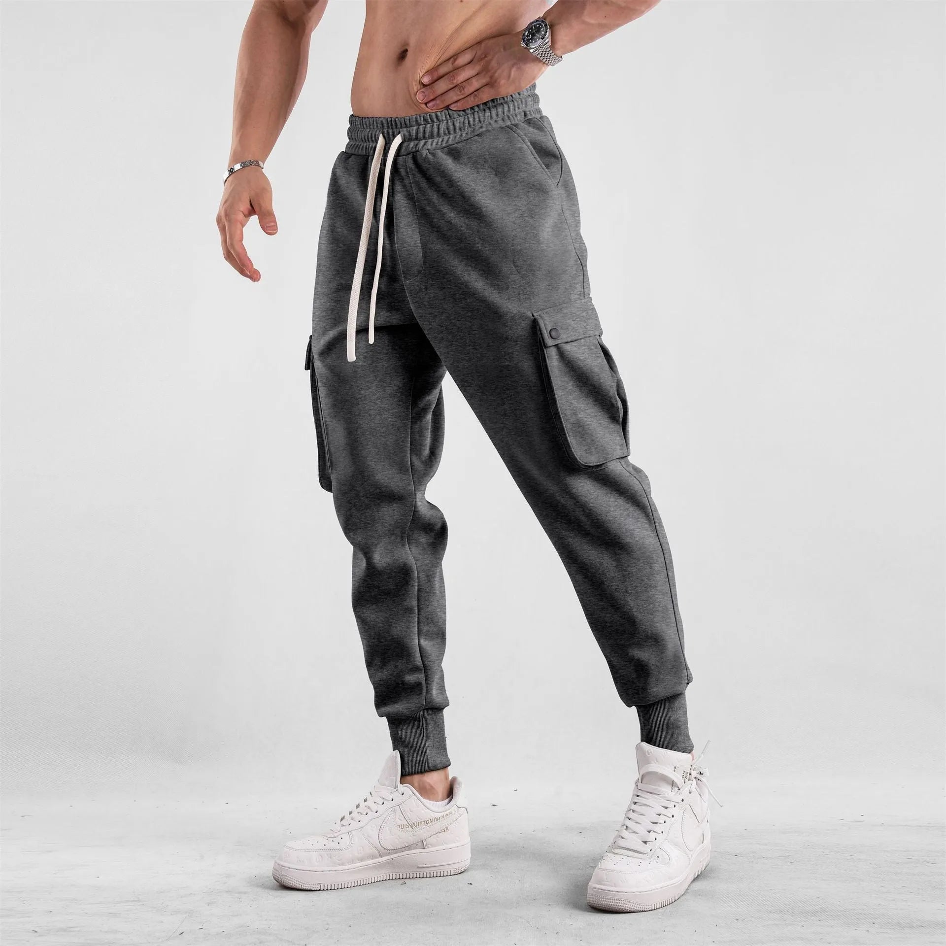 Men's loose-fit apricot coloured cotton sports trousers with an ankle tie and side pockets on a neutral background.