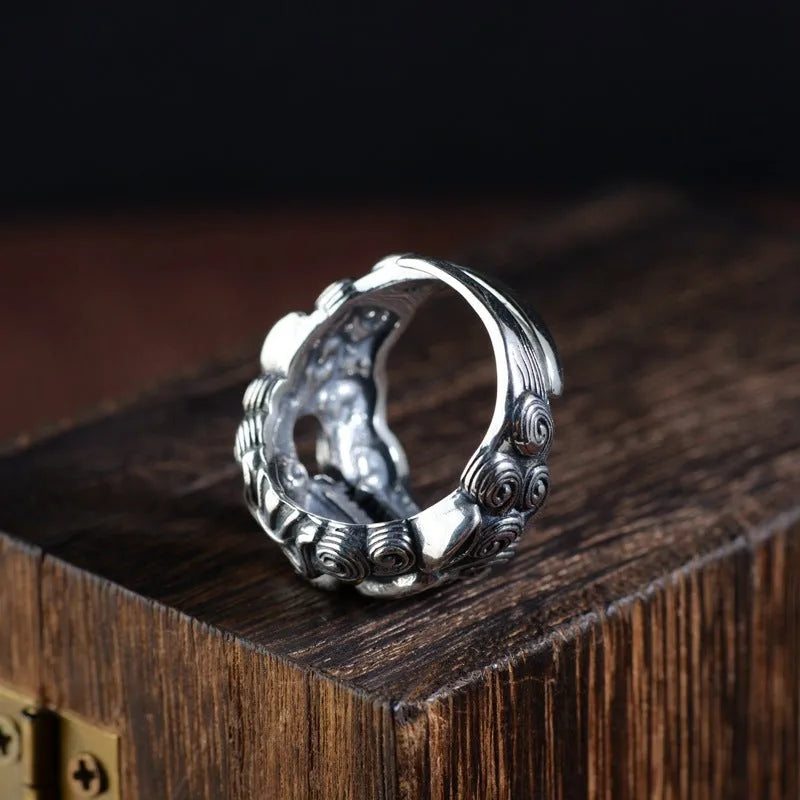 Silver open-ended ring with a raised Domineering Jibeast animal zodiac pattern.