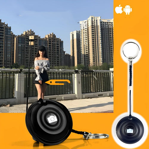 Black Bluetooth remote control for selfies with a single snap button on a white background.