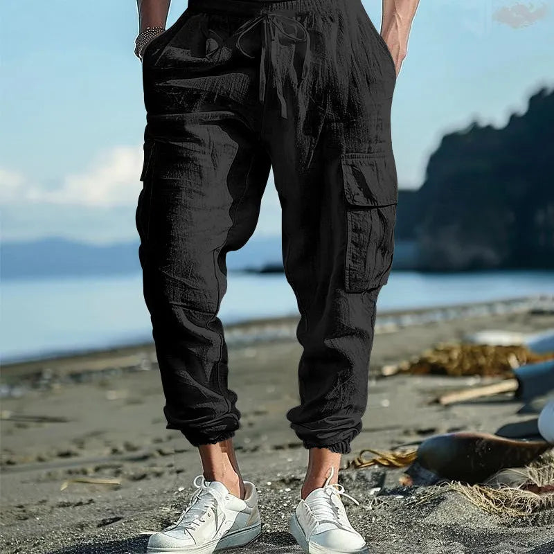 Men's linen casual trousers with ankle-tied cuffs and multiple pockets in a solid colour.
