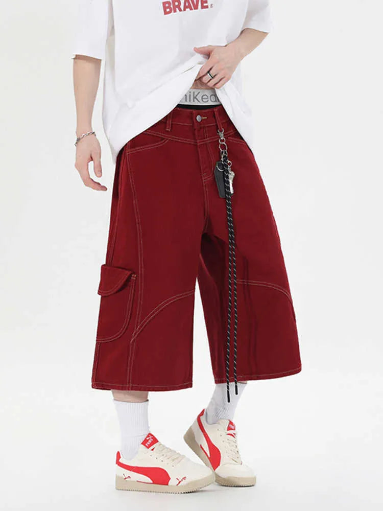 Red and black denim workwear shorts with multiple pockets, cropped length, and wide leg design