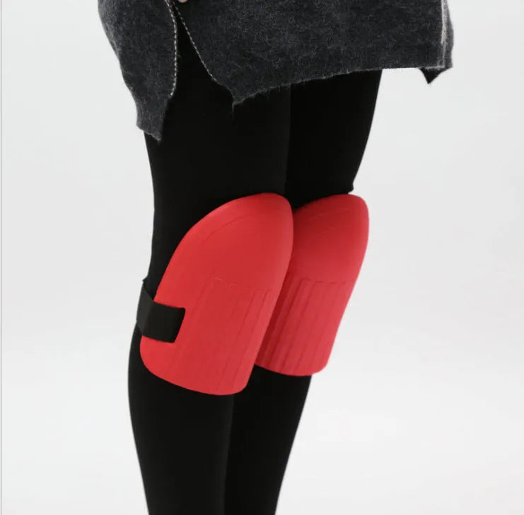 A pair of rectangular EVA foam knee pads in army green colour on a garden soil background.