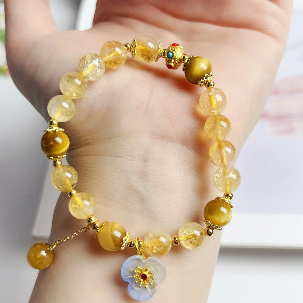 Close-up of a handcrafted citrine crystal bracelet for women with a floral tassel pendant.