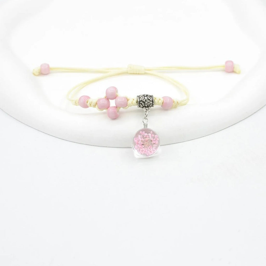 Hand-woven glass bracelet with large beads containing real dried flowers, shown in multiple colour options.
