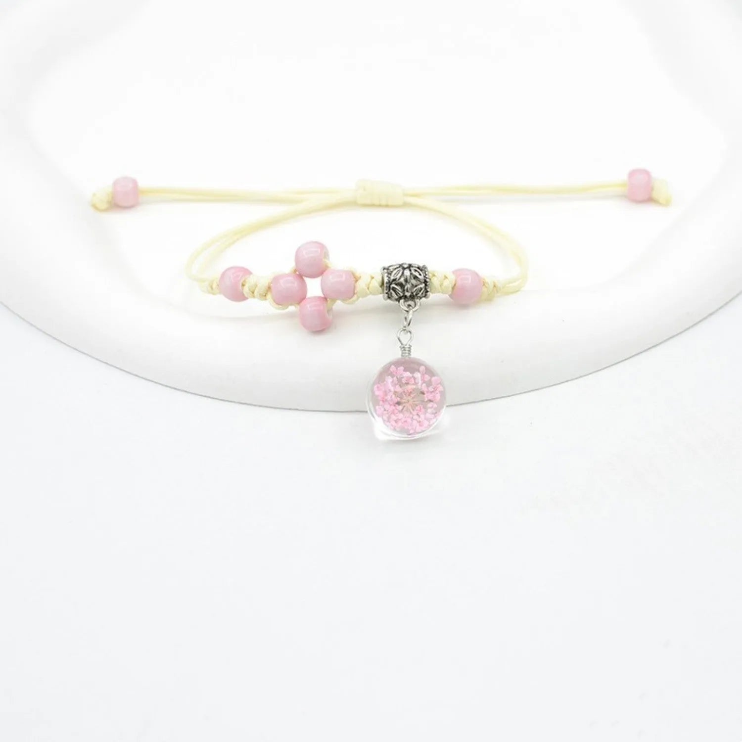 Hand-woven glass bracelet with large beads containing real dried flowers, shown in multiple colour options.