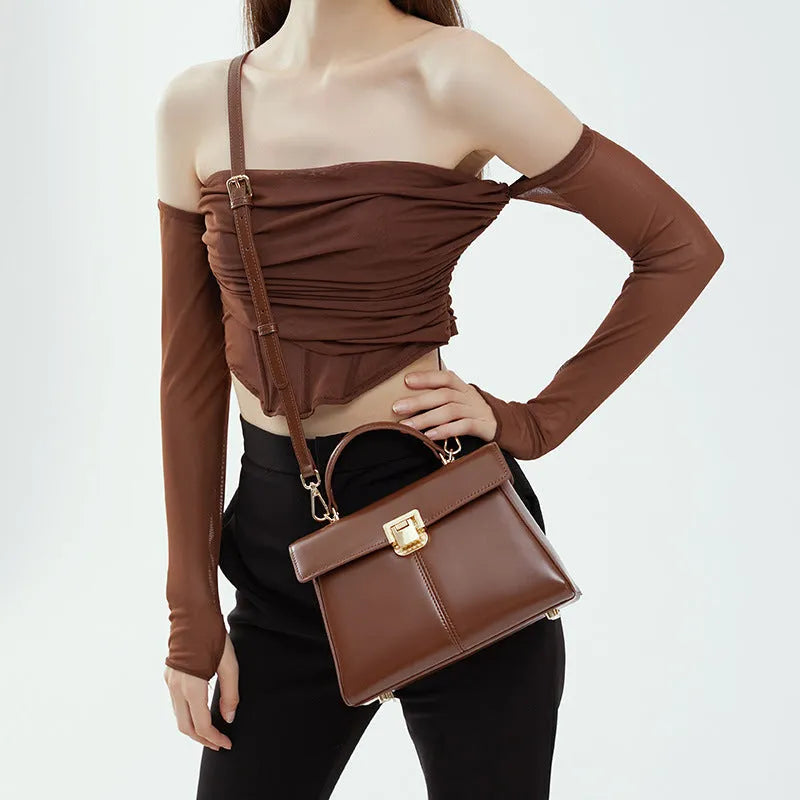 Genuine leather women's clasp shoulder bag in black, showing horizontal square shape and strap.