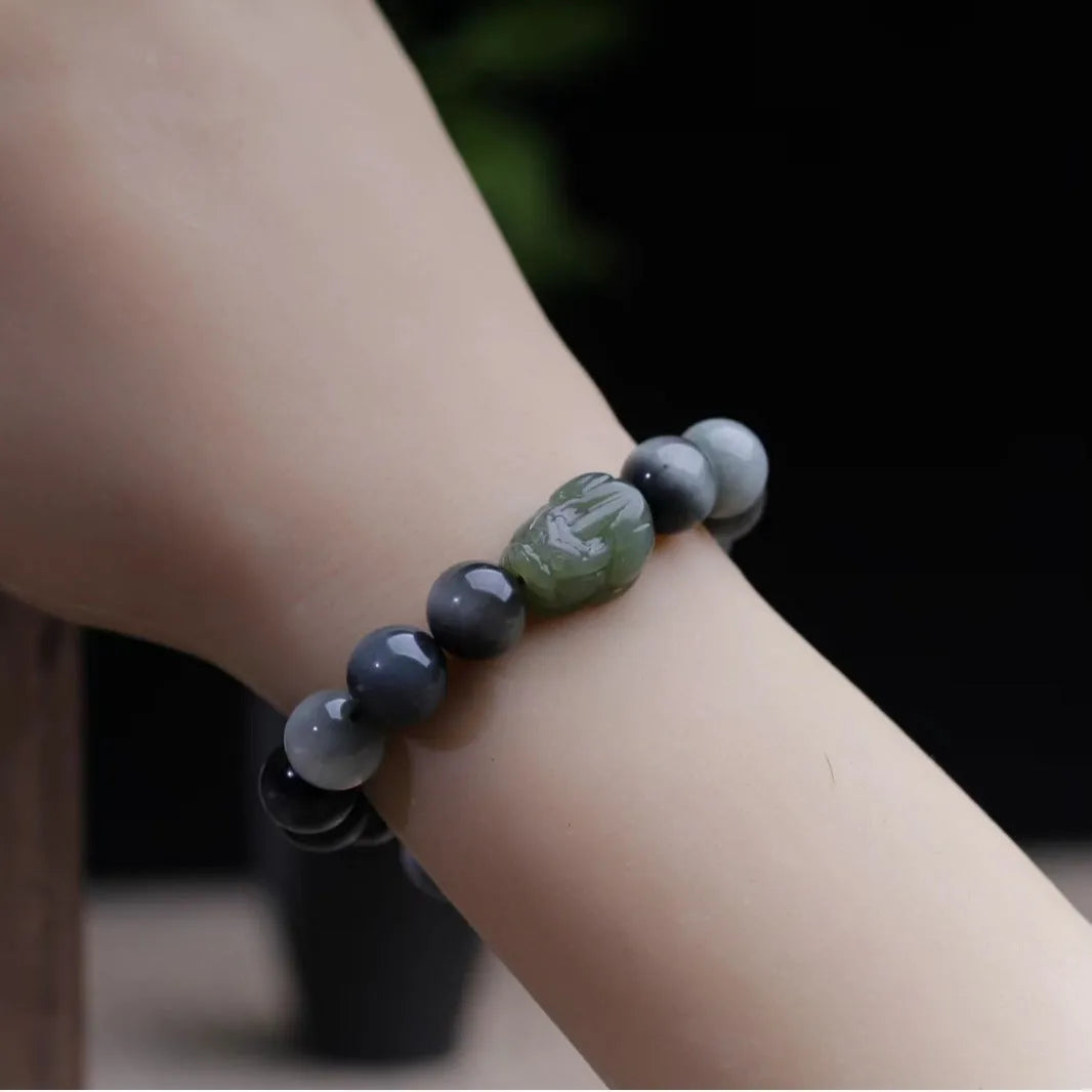 Black 10mm Eagle Eye Stone bracelet with a natural Hetian Jade Pixiu charm showing a clear water pattern.