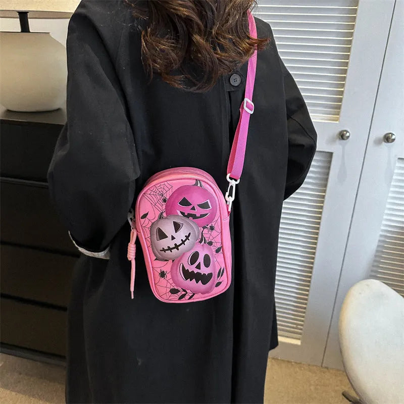 Black mini square crossbody bag with orange Halloween graffiti print of cartoon pumpkin, ghost, and bat.