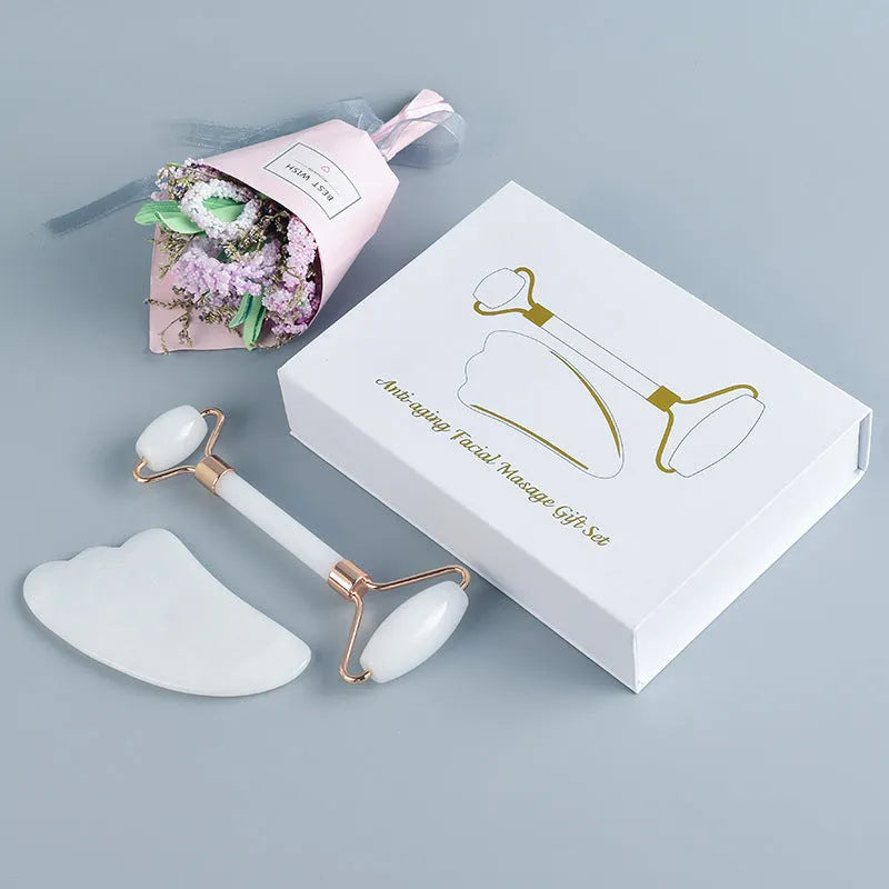 White jade facial roller and Gua Sha scraping board set on a neutral background.