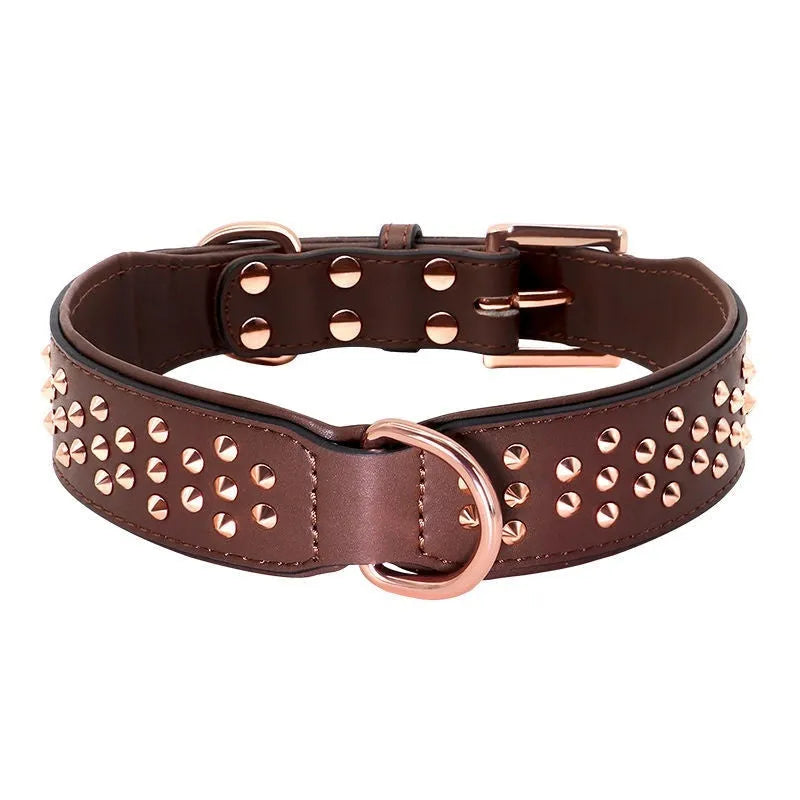 A brown leather dog collar with a row of shiny brass anti-bite rivets and a metal D-ring.