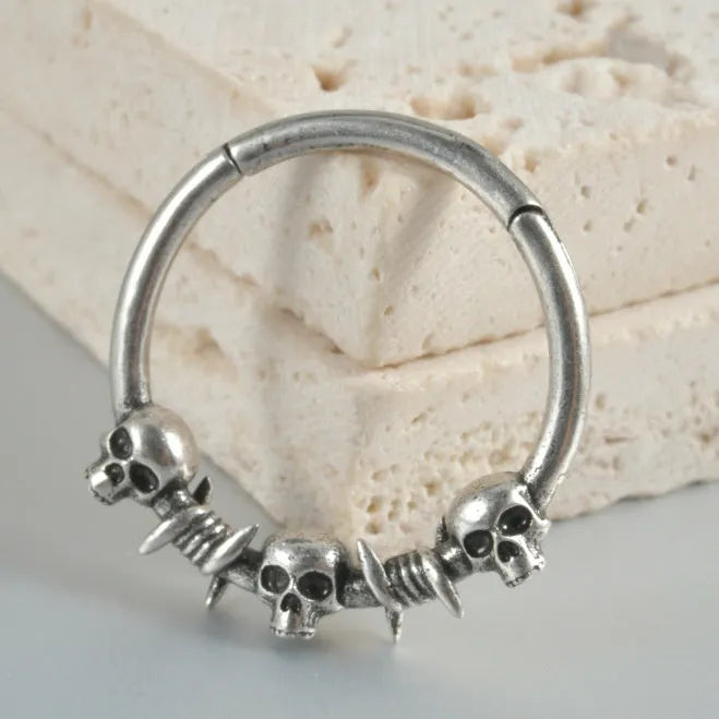 Copper punk earring with antique silver ghost head design on a white background.