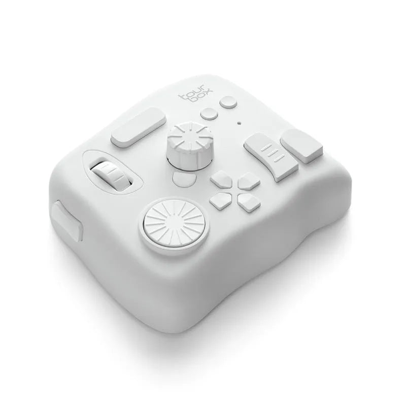 TourBox NEO black video editing controller with dials and buttons on a desk.