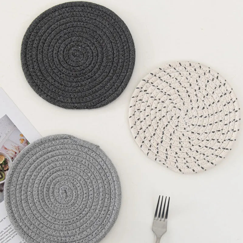 Three round cotton cord coasters in blue, measuring 18cm diameter, on wooden table