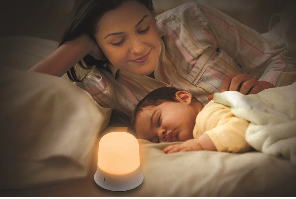White cylindrical touch control bedside night light with USB charging cable.