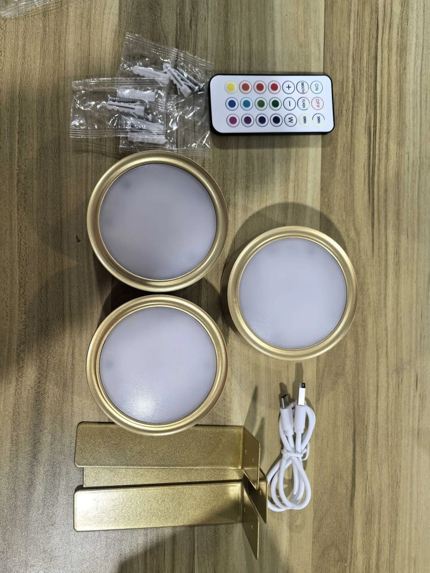 Black magnetic wireless LED lamp with remote control mounted next to a painting on a wall.