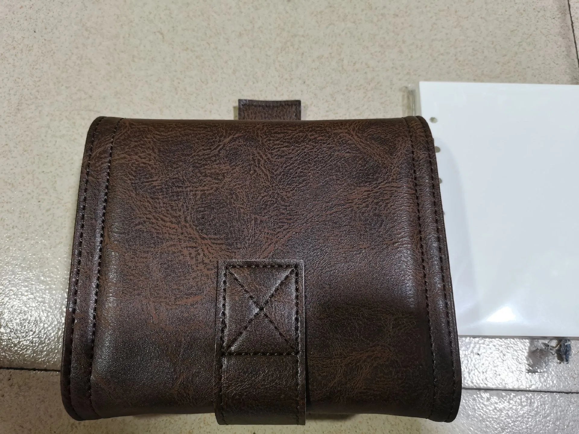 Brown retro-style A7 notebook with a PU leather-look cover and metal buckle closure, showing loose-leaf binding.