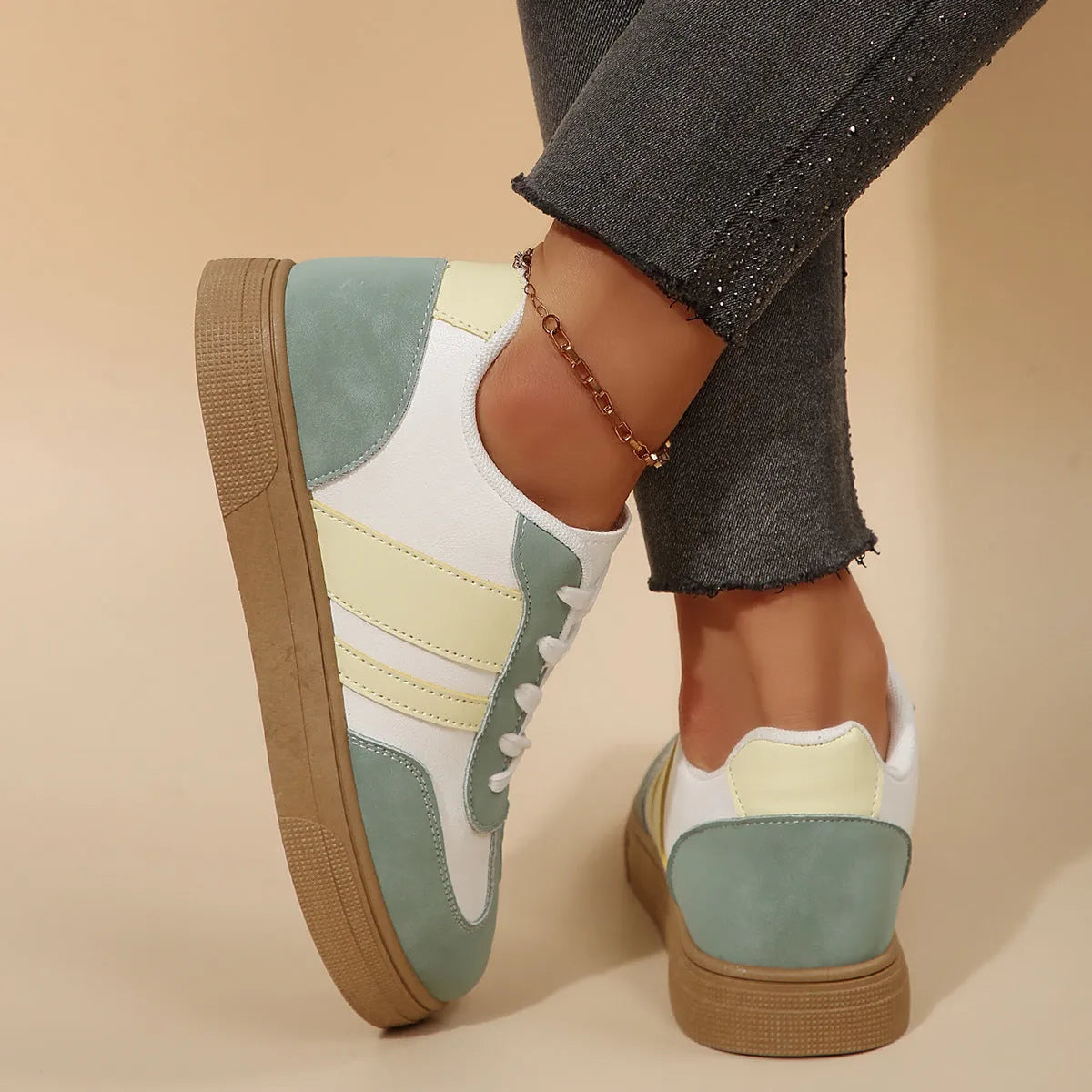 Green women's retro sports pumps with cross straps, leather stitching, and a round toe on a rubber sole.