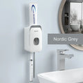 Blue automatic toothpaste dispenser made of ABS plastic mounted on a bathroom wall.