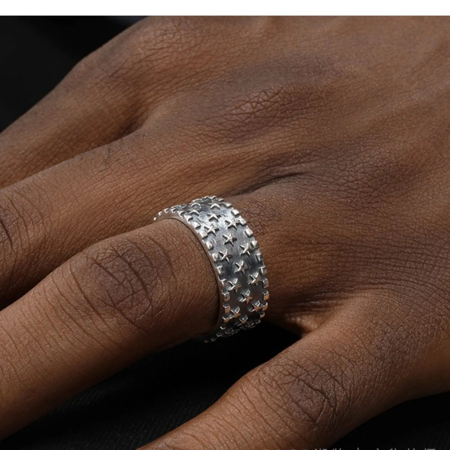 Adjustable open-back sterling silver ring with a geometric five-pointed star pattern.