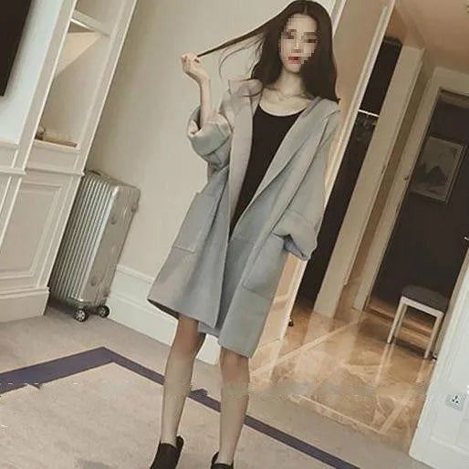 Plus size woman wearing a grey loose-fit cotton coat with lace detailing and long sleeves.