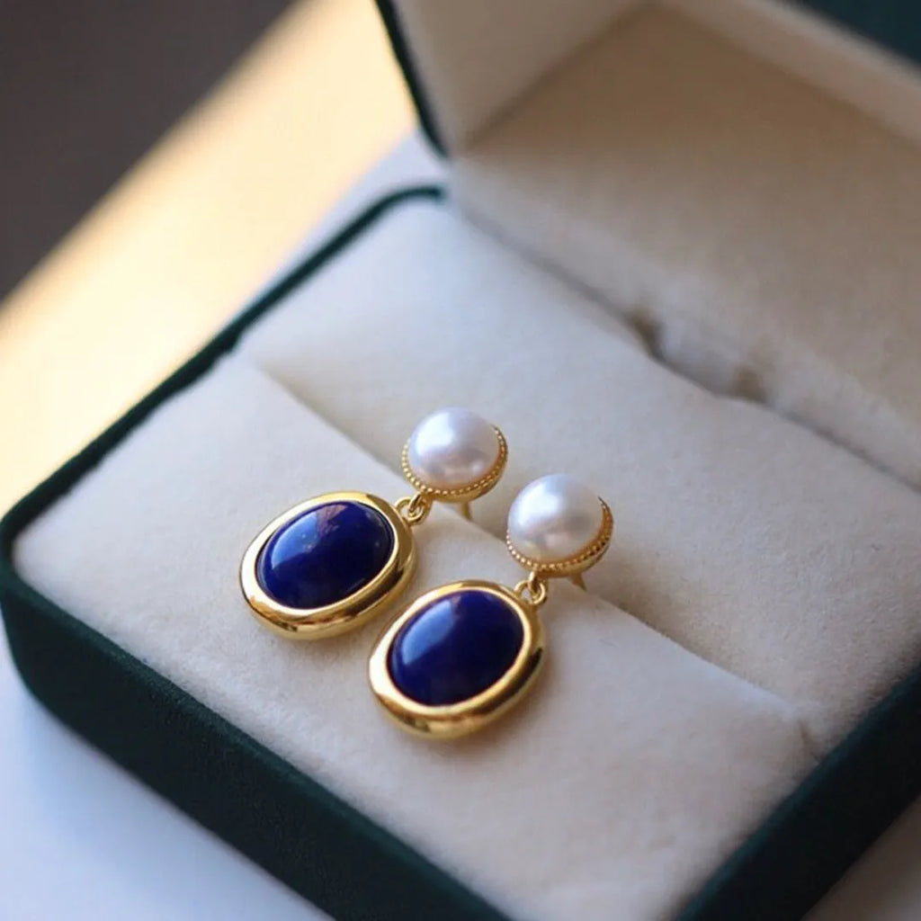A pair of simple sterling silver earrings featuring deep blue lapis lazuli pearls.