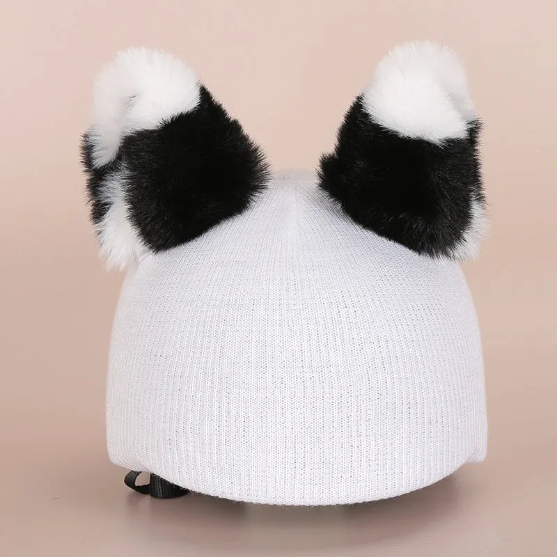 Soft plush cartoon-style decoration sitting on a ski helmet.