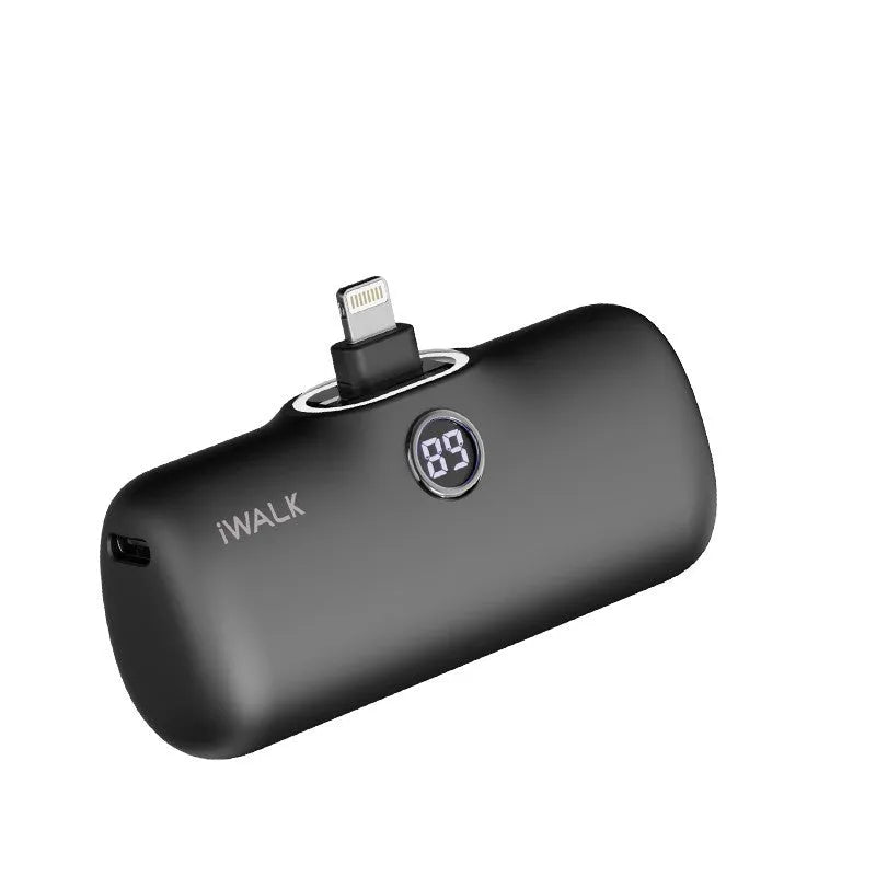 Compact white lipstick-shaped power bank with digital battery percentage display on a wooden table.