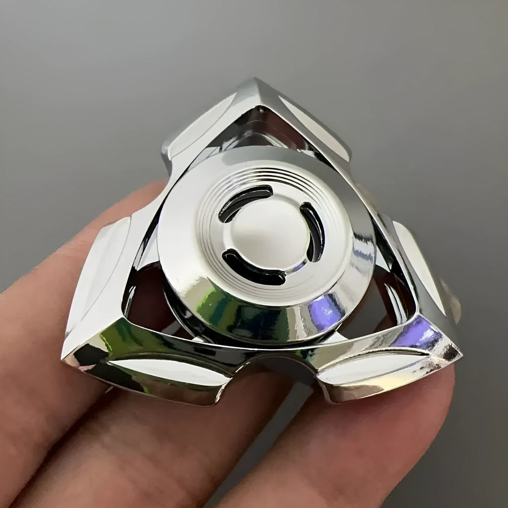 Silver and colourful alloy fingertip gyro decompression fidget toy on a plain background.