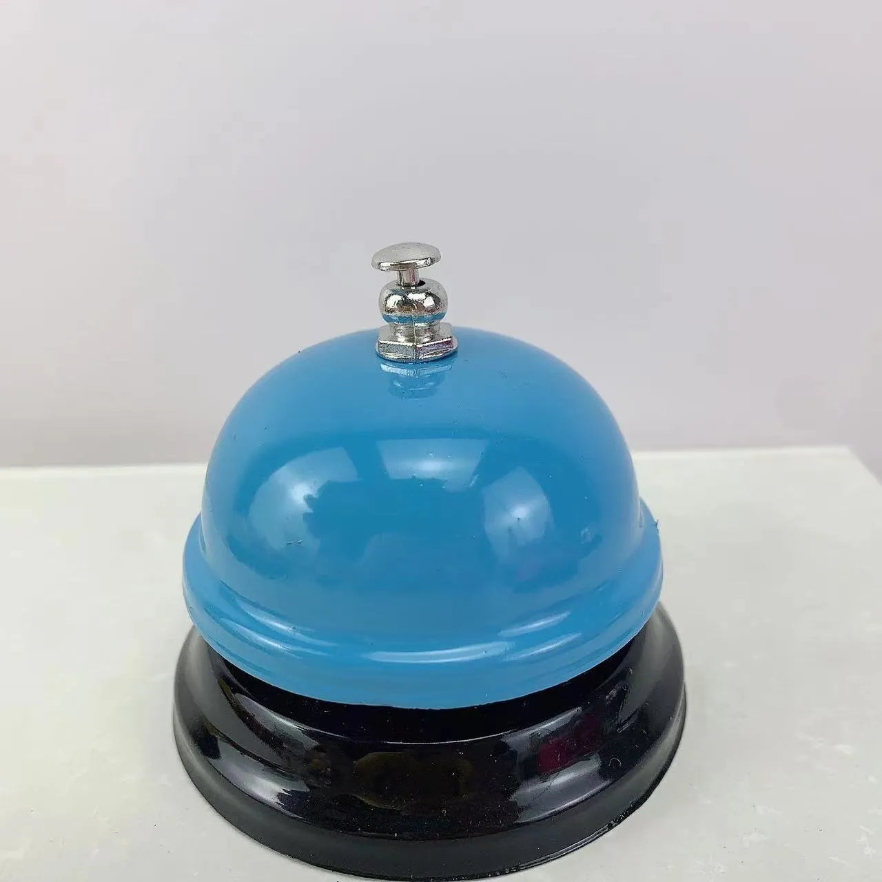 Iron game bell in assorted colours including red, blue, green, pink, and yellow for service or classroom use.