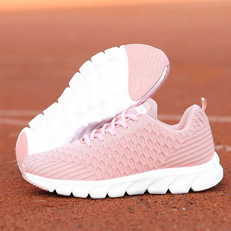 Women's running shoes in black, pink, or white with a mesh upper and rubber outsole.