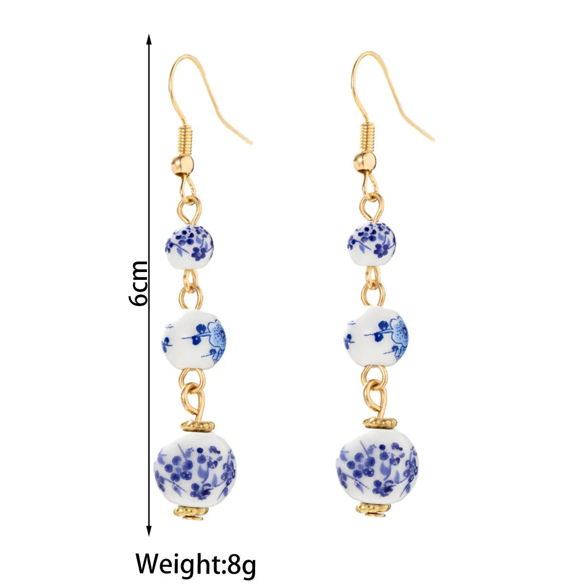 Long blue and white porcelain ceramic bead earrings with geometric alloy details on a white background.