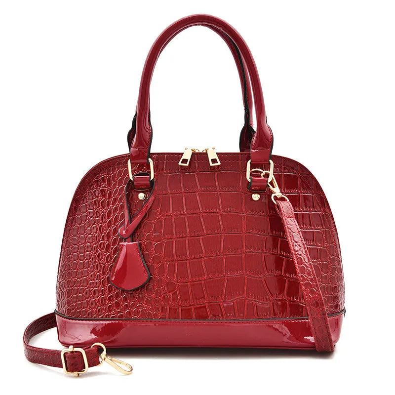 Shiny PU crossbody bag with shell shape, shown in black, red, or brown colour options