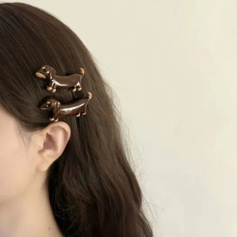Dachshund dog shaped hair barrettes with electroplated finish, shown as a single clip or a pair.