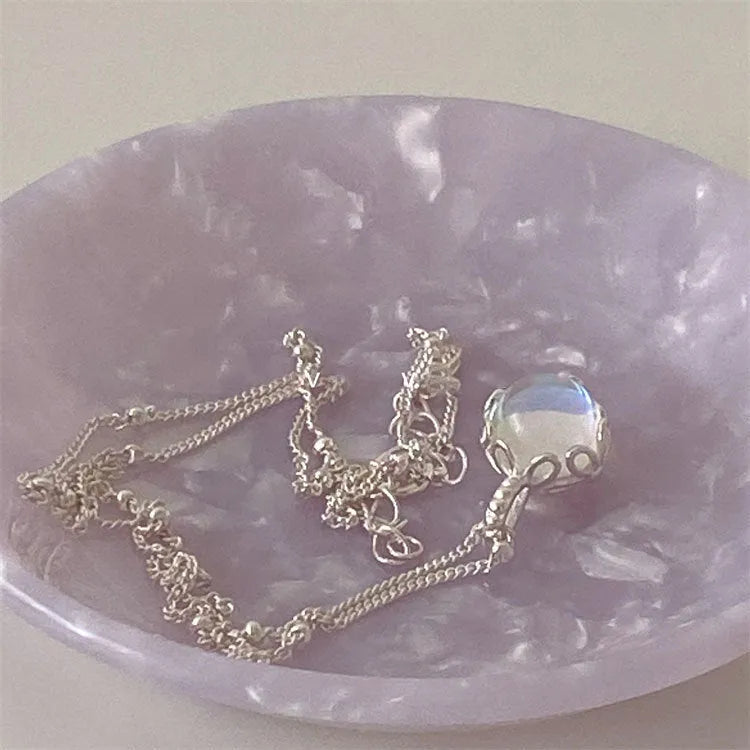 Women's silver necklace with a geometric stone pendant on a curb chain.