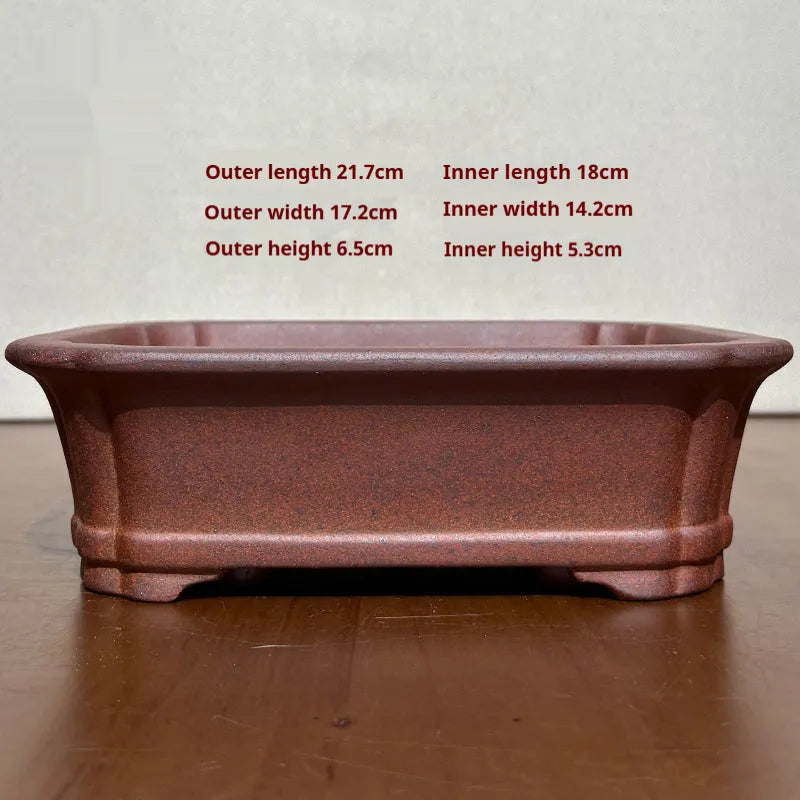 Reddish brown hand-glazed stoneware rectangular bonsai flower pot on a flat surface