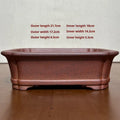 Reddish brown hand-glazed stoneware rectangular bonsai flower pot on a flat surface