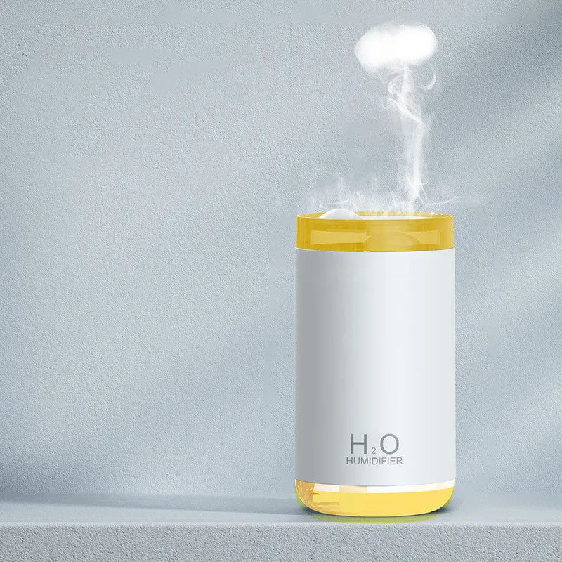 White jellyfish-shaped USB humidifier with warm night light on wooden surface