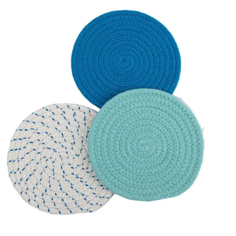 Three round cotton cord coasters in blue, measuring 18cm diameter, on wooden table