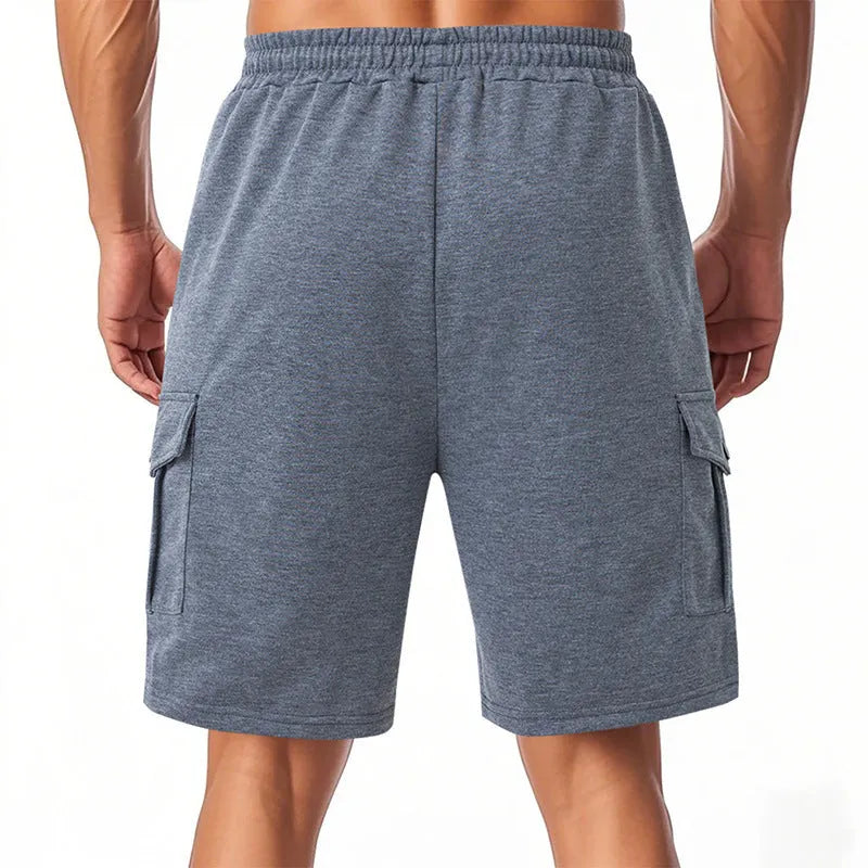 Men's loose-fit grey terry fabric cargo shorts with multiple pockets on a plain background.