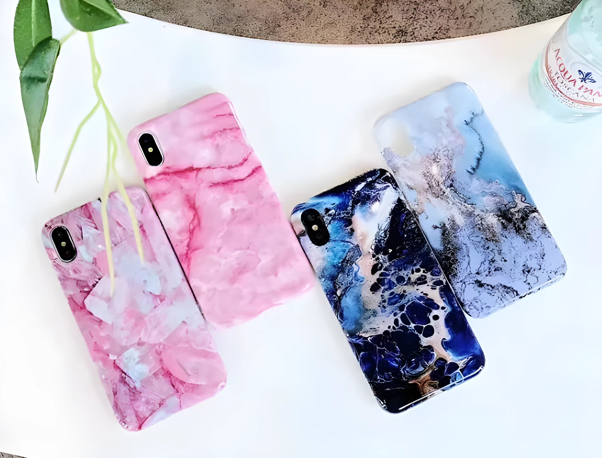 Colourful stone pattern soft protective case for iPhone X, 8, 7, 6, and 6s Plus models on a table.