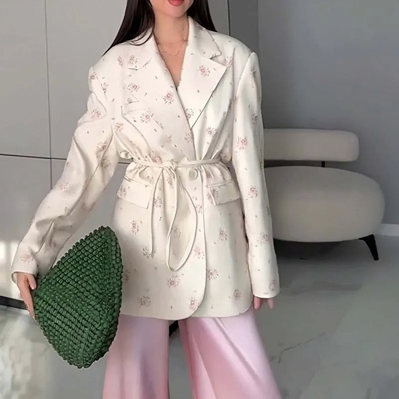 A printed suit jacket with a lace-up collar detail and waist-tightening feature on a mannequin.
