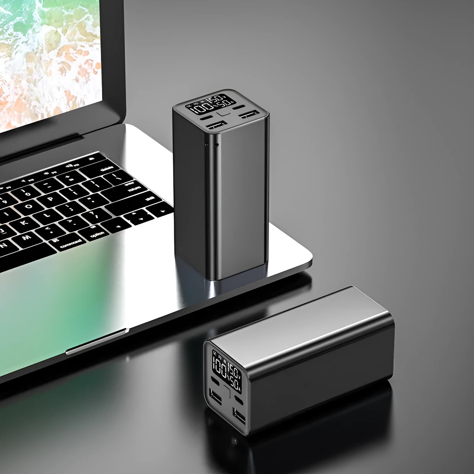 Black metal 65W laptop power bank with 20000mAh capacity showing size next to a laptop.