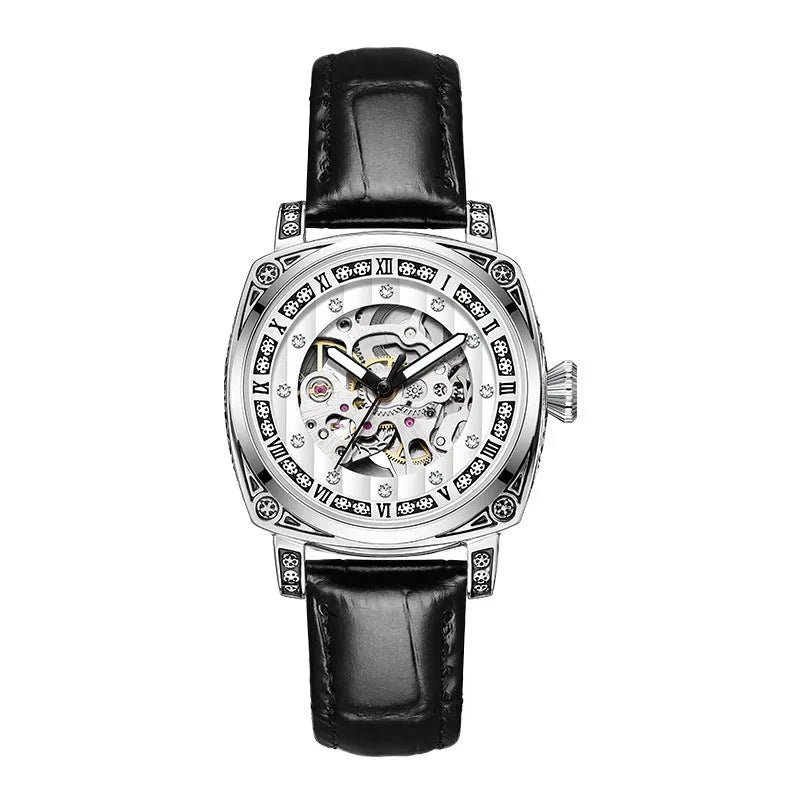 Men's black leather strap mechanical watch with luminous hands on a wrist.
