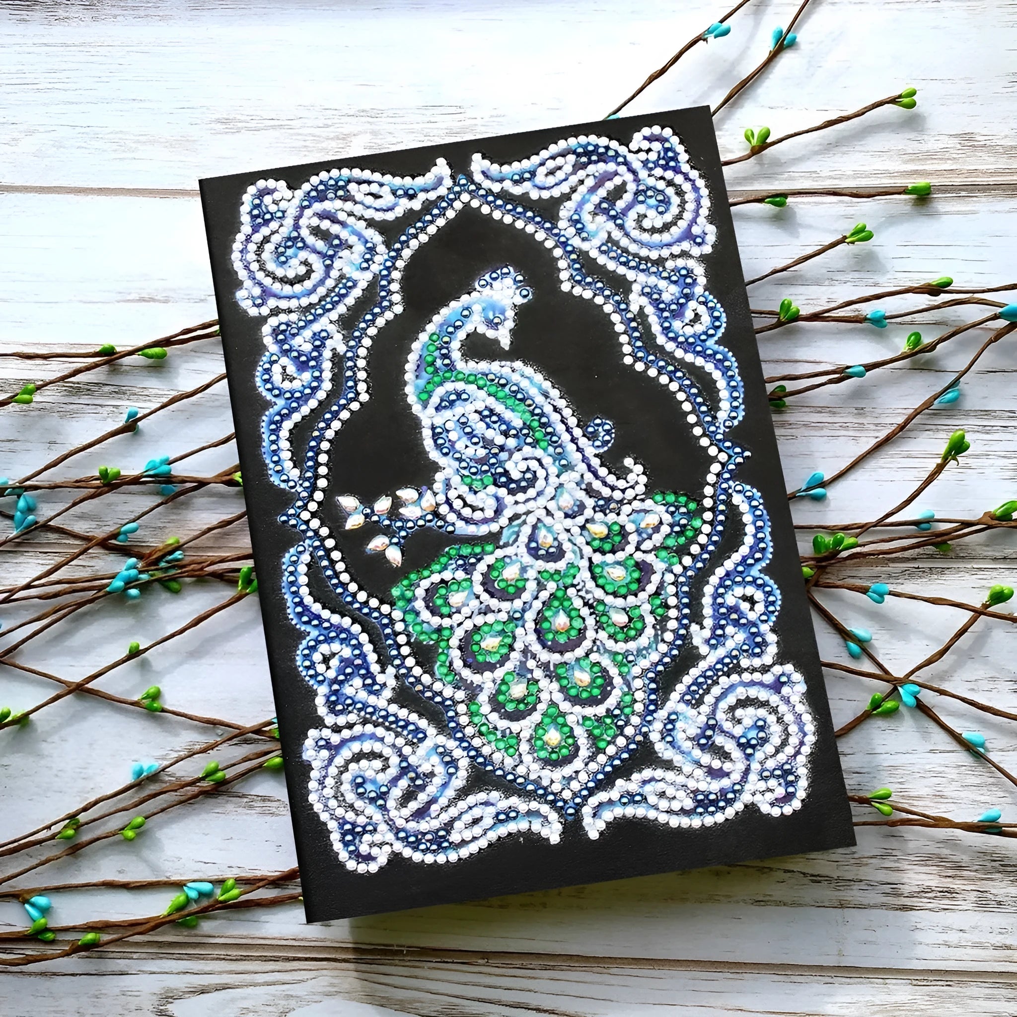 Black A5 Peacock Beauty diamond painting notebook with sparkling shaped drills on cover, showing 142x207mm size.