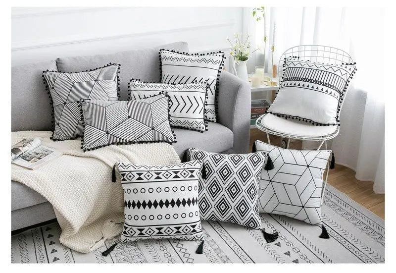 Bohemian style decorative throw pillow with polyester cover in light grey on a sofa.