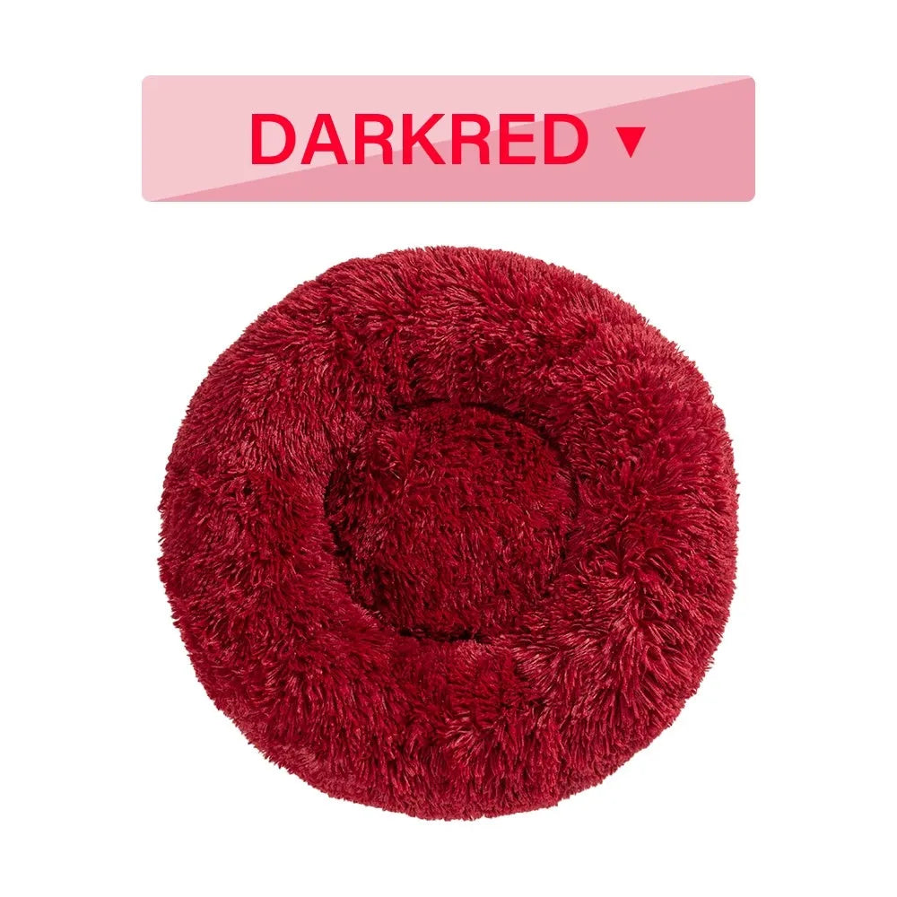 Fluffy grey donut-shaped dog bed with high plush sides on a wooden floor.