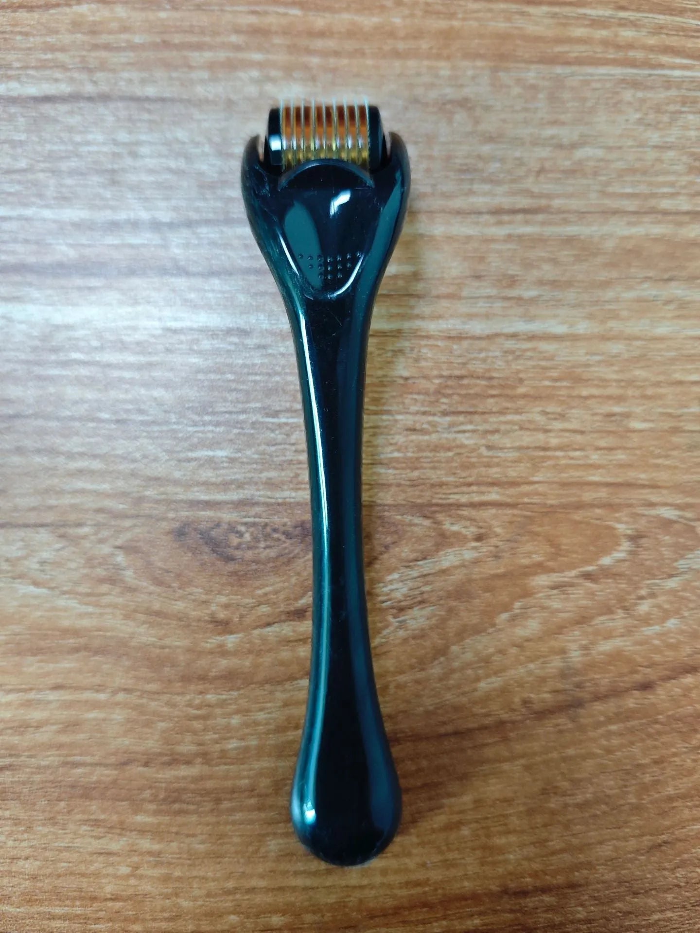 540 micro needle roller tool with black handle and coloured wheel on a white background.