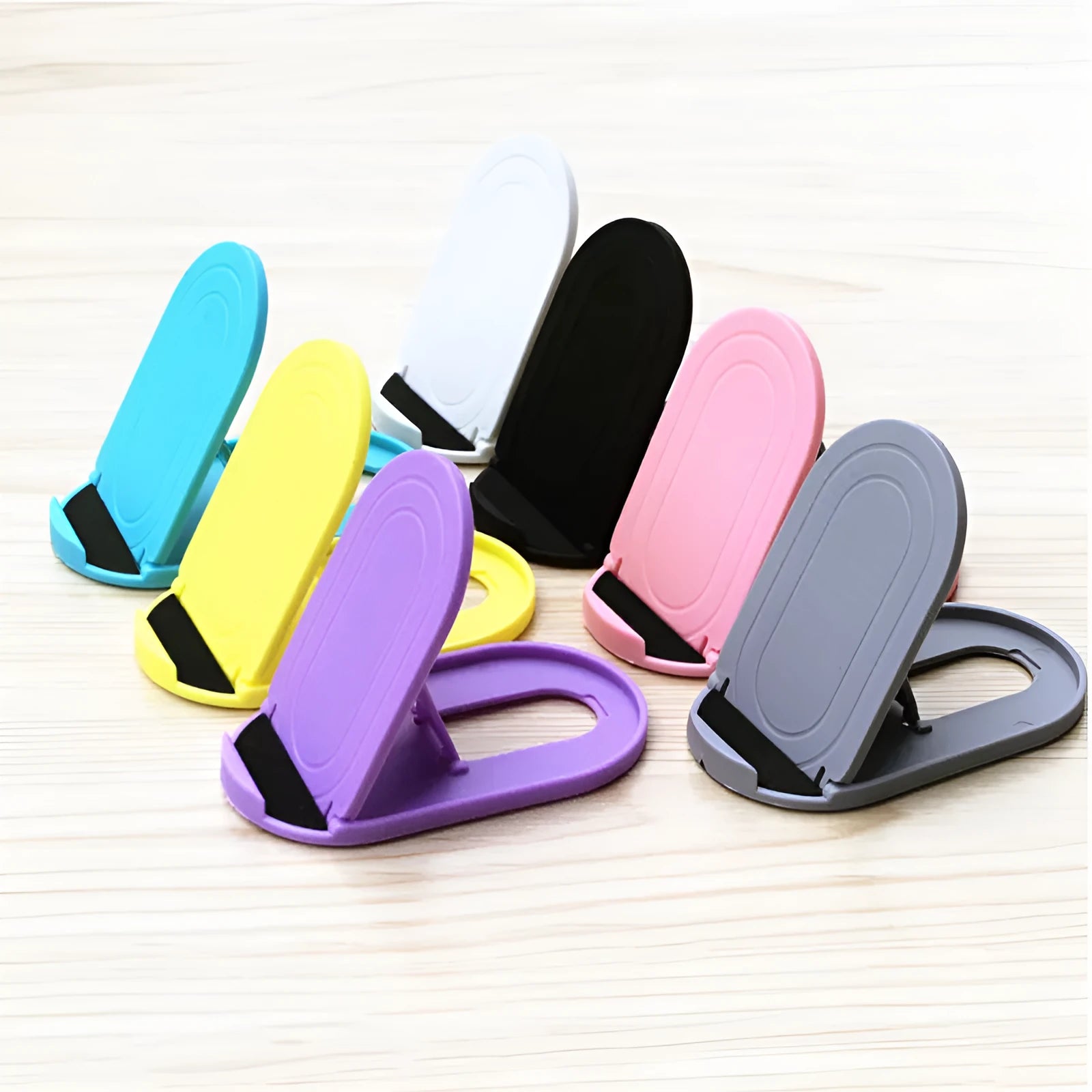Plastic lazy bracket phone stand holding a mobile phone, shown in multiple colour options