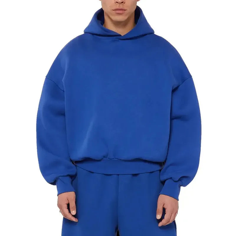 A man's solid-colour fleece-lined cotton hoodie with a wool interior, shown in a casual setting.