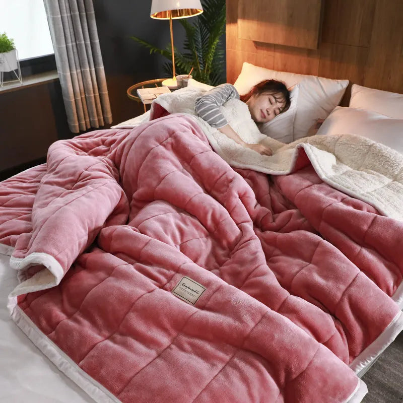 Thick coral fleece winter blanket in a solid colour, shown on a bed, dimensions 150cm by 200cm.